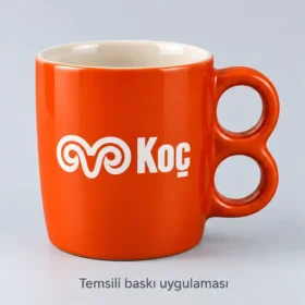 Alucra Çift Halkalı Stoneware Kupa, turuncu dış, krem iç renk önerisi ve Koç Holding logosuyla temsili baskı uygulaması. Renk ve uygulama numuneyle teyit edilir; gerçek müşteri siparişi fotoğrafı değildir.
