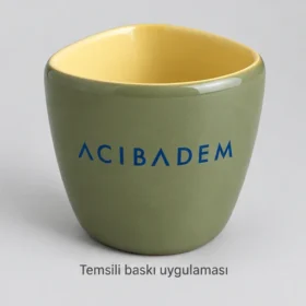 Niksar Üçgen Kesitli Stoneware Kupa: Acıbadem logosunun dış yüzeyde temsili baskı uygulaması; üretilmiş numune veya gerçek müşteri siparişi fotoğrafı değildir.